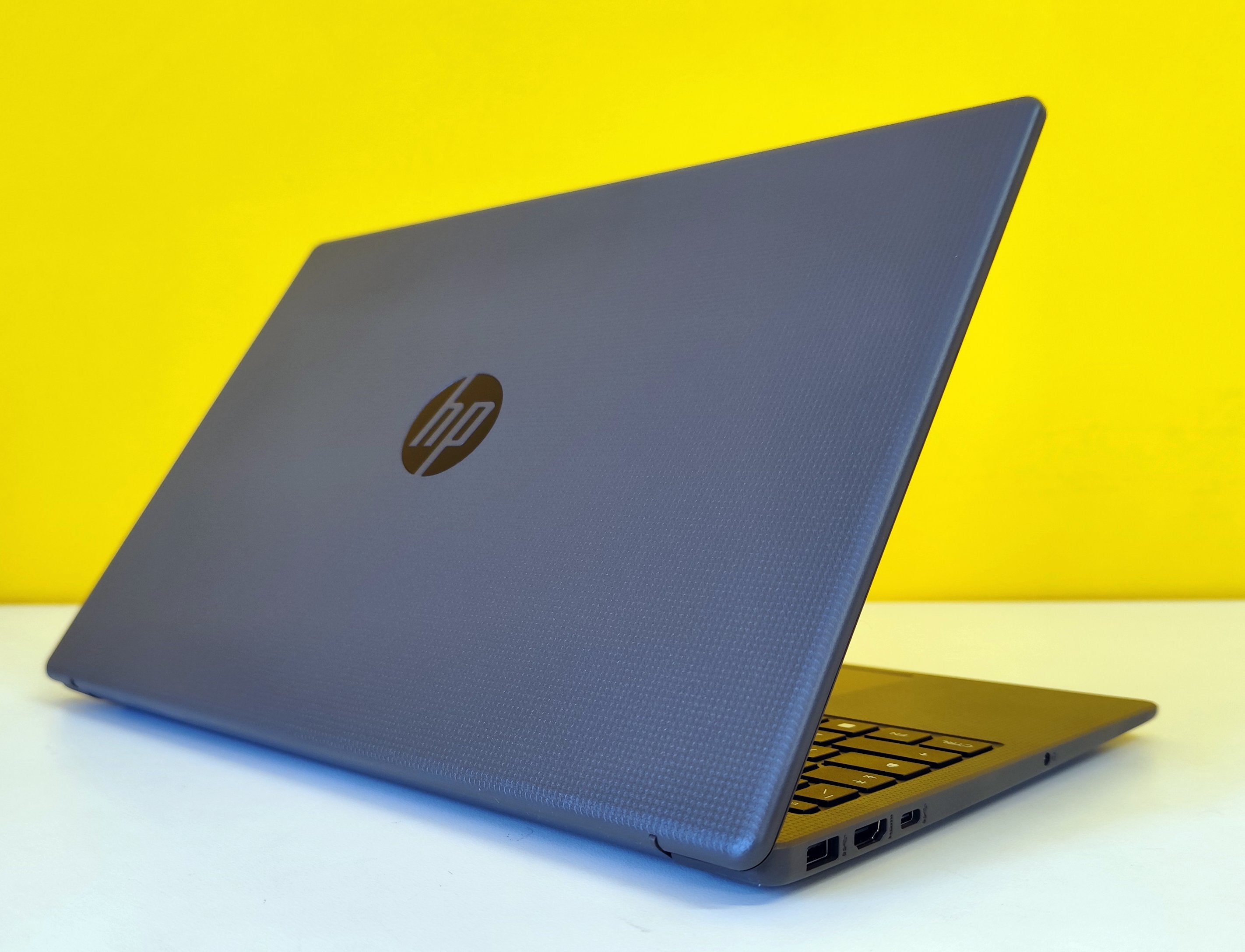 Notebook HP 250 G10 semiaperto con finitura grigia e porte laterali visibili, design moderno e resistente. Notebook HP 250 G10 semiaperto con finitura grigia e porte laterali visibili, design moderno e resistente.